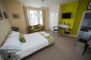 a bedroom with a large bed and a living room at Studios At Glenthorne in Merthyr Tydfil