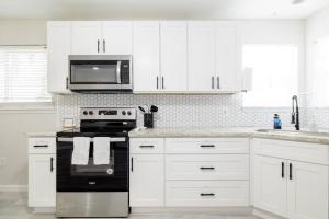 a kitchen with white cabinets and a stove and microwave at 2 bed 2 bath Modern Farmhouse in Old Town Spring in Spring