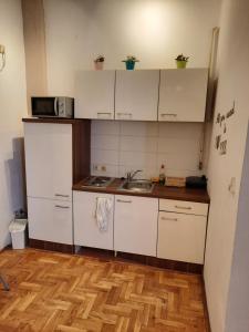 a small kitchen with white cabinets and a sink at Studio apartment in Zagreb