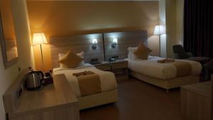 una camera d'albergo con due letti e un divano di Holiday Hotel Addis Ababa ad Addis Abeba