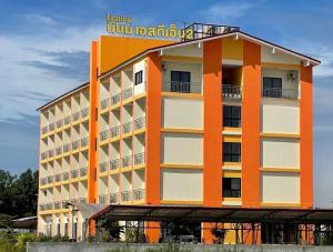 un edificio naranja y blanco con un cartel en él en โรงแรมนิยม เอสทีเอ็น 2 - Niyom STN 2 Hotel, en Ban Phue