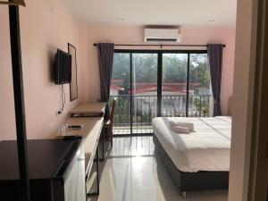 Habitación de hotel con cama y ventana grande en โรงแรมนิยม เอสทีเอ็น 2 - Niyom STN 2 Hotel, en Ban Phue