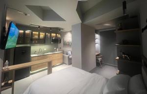 1 dormitorio con 1 cama y cocina con TV en Unique Mine Luxury SMART LOFTS, en Bogotá