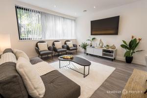 a living room with a couch and a tv at STUNNING Townhouse, Sleeps 8, Garden & Parking - Carbery Ridge in Bournemouth