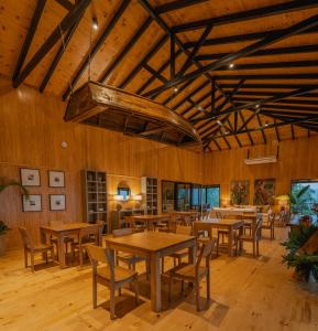 una sala da pranzo con tavoli e sedie in legno di Reserva Natural Iguazú - Pristine Luxury Camp a Puerto Libertad