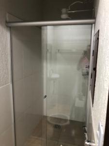 a shower with a glass door in a bathroom at Suítes Saraiva in Uberlândia