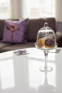 a glass dish with donuts in it on a table at Studios At Glenthorne in Merthyr Tydfil