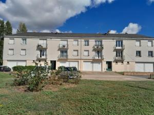 a large white building with balconies in a yard at Le Descartes in Descartes