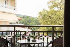 a table and chairs on a balcony with a view at Olymp-rooms in Litochoro