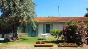 una casa con una mesa y una silla en el patio en Maison de 3 chambres avec piscine partagee et jardin amenage a Saintes Maries de la Mer, en Saintes-Maries-de-la-Mer