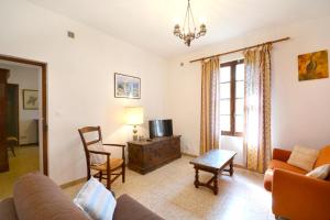 a living room with a couch and a tv at Charmante maison en Camargue avec piscine partagée in Saintes-Maries-de-la-Mer