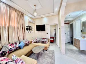 a living room with a couch and a tv at Famille Hanae appartement avec terasse in Marrakech