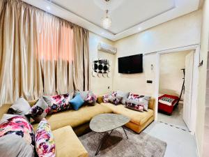 - un salon avec un canapé et une télévision dans l'établissement Famille Hanae appartement avec terasse, à Marrakech