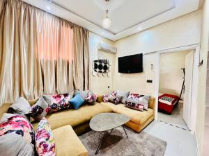 a living room with a couch and a tv at Famille Hanae appartement avec terasse in Marrakech
