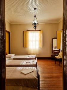 a hospital room with two beds and a chandelier at Casarão Solar dos Almeida in Diamantina