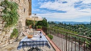 a patio with a table and chairs and an umbrella at Casa Girasole in Gaiole in Chianti