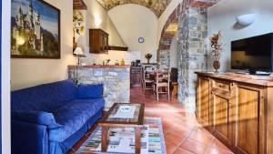 a living room with a blue couch and a kitchen at Casa Girasole in Gaiole in Chianti