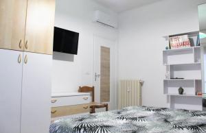 een slaapkamer met een bed en een tv aan de muur bij Renesmee Beach Apartment in Pietra Ligure