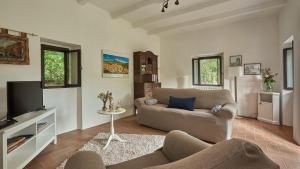 uma sala de estar com um sofá e uma televisão em La Mita em Cortona