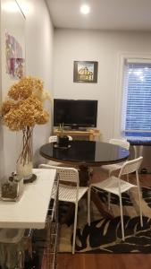 a living room with a table and chairs and a tv at Tina's place in Ottawa