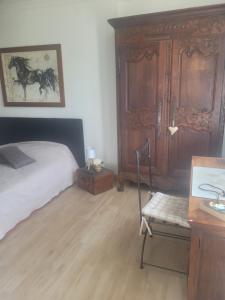 - une chambre avec un lit et un bureau avec une chaise dans l'établissement Petite maison avec jardin et cheminée, 