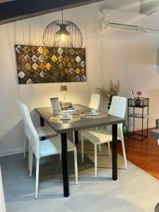 comedor con mesa y sillas blancas en StaraGo Apartment, en Gorizia