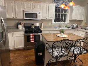 a kitchen with white cabinets and a stove top oven at Lynchburg Leisure in Lynchburg