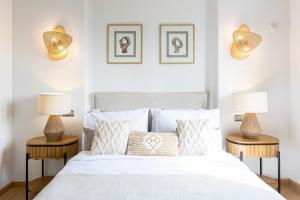 a bedroom with a white bed with two night stands at Sunny Home in Benalmádena