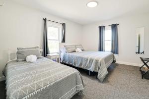a bedroom with two beds and two windows at Dom Rodzinny Lakeview Getaway - Walk to Lake Huron in Rogers City