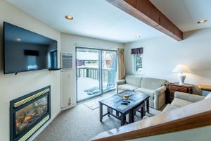un soggiorno con camino e TV di Smugglers' Notch Resort Private Suites a Cambridge
