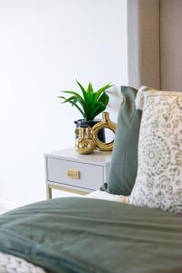 米爾頓凱恩斯的住宿－Elegant central apartment，一张桌子上的床,上面有植物