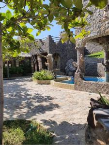 a stone house with a courtyard with a fountain at Fort Mughaibar Resort in Hatta