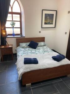 um quarto com uma cama com almofadas azuis em Converted chapel - Sant Pedr Newydd - with sea views em Amlwch