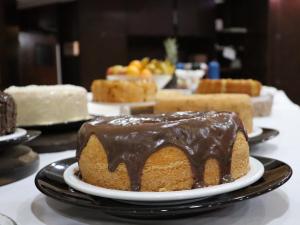um bolo de chocolate num prato numa mesa com outros bolos em Guarita Park Hotel - By Life Hotéis em Torres