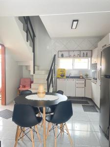 eine Küche mit einem Tisch und Stühlen im Zimmer in der Unterkunft Condomínio Moradas da Vila in Imbituba