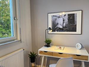 biurko w pokoju z obrazem na ścianie w obiekcie Karls Apartment - B24 w mieście Gera