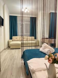 Habitación de hotel con cama y sofá en Apartment Korkem-3 at Left Coast in Astana, en Taldykolʼ
