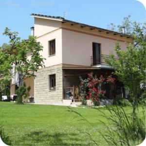 een groot huis met een groene tuin met een huis bij Camping Le Marche Apartments in Gualdo di Macerata