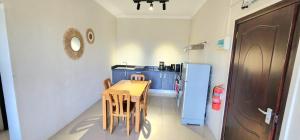a small kitchen with a table and a refrigerator at Number 7, 2nd floor, Pebble Bay Apartments with Garden View in Grand Baie
