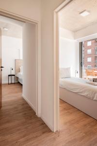 a white bedroom with a bed and a window at Top Rentals Deheza in Buenos Aires