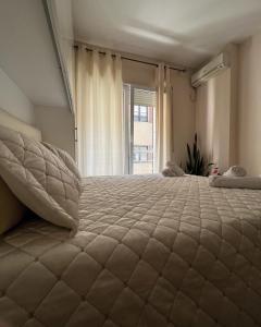 um quarto com uma cama grande e uma janela em Sindi's Daily Apartment em Durrës