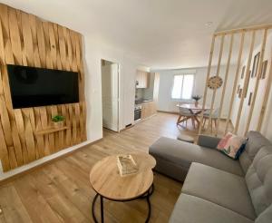 a living room with a couch and a table at Charmante MAISON Lumineuse, Chaleureuse et confortable in Julienne