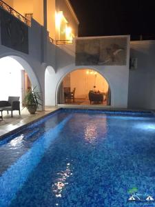 a swimming pool in a villa with a house at Villa Amine Flouka in Houmt Souk
