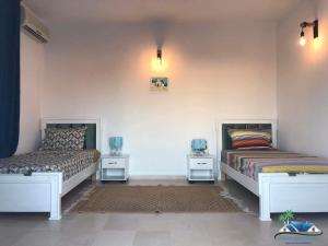 duas camas sentadas uma ao lado da outra num quarto em Villa Amine Flouka em Houmt Souk