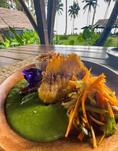 ein Teller mit Fleisch und Gemüse auf dem Tisch in der Unterkunft Eco Sanctuaries Nature Lodge Nacpan Beach, El Nido in El Nido