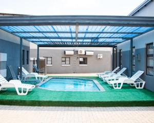 uma piscina com espreguiçadeiras e uma piscina em Boeketlong Lodge em Jane Furse