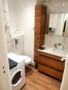 een badkamer met een wasmachine en een wastafel bij Résidence Le Château in Montbéliard