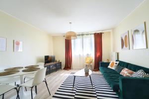 a living room with a green couch and a table at appartement cosy et charme au coeur de Besancon in Besançon