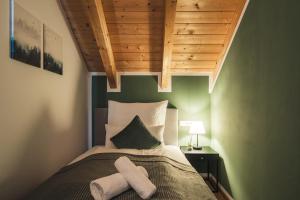 um quarto com uma cama com duas toalhas em ALPSTAY "Kuhstadl" - Maisonette, Gondelnähe & Netflix em Bad Kleinkirchheim