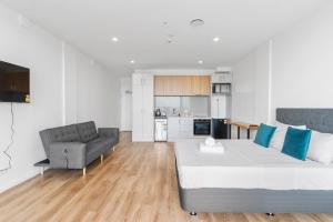 uma sala de estar com uma cama grande e um sofá em Manukau Studio Apartments em Auckland